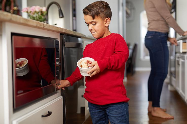 Photo of a child with Achondroplasia cooking in a kitchen