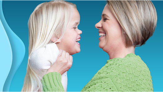 Photo of woman holding a child with Achondroplasia close to her face and smiling
